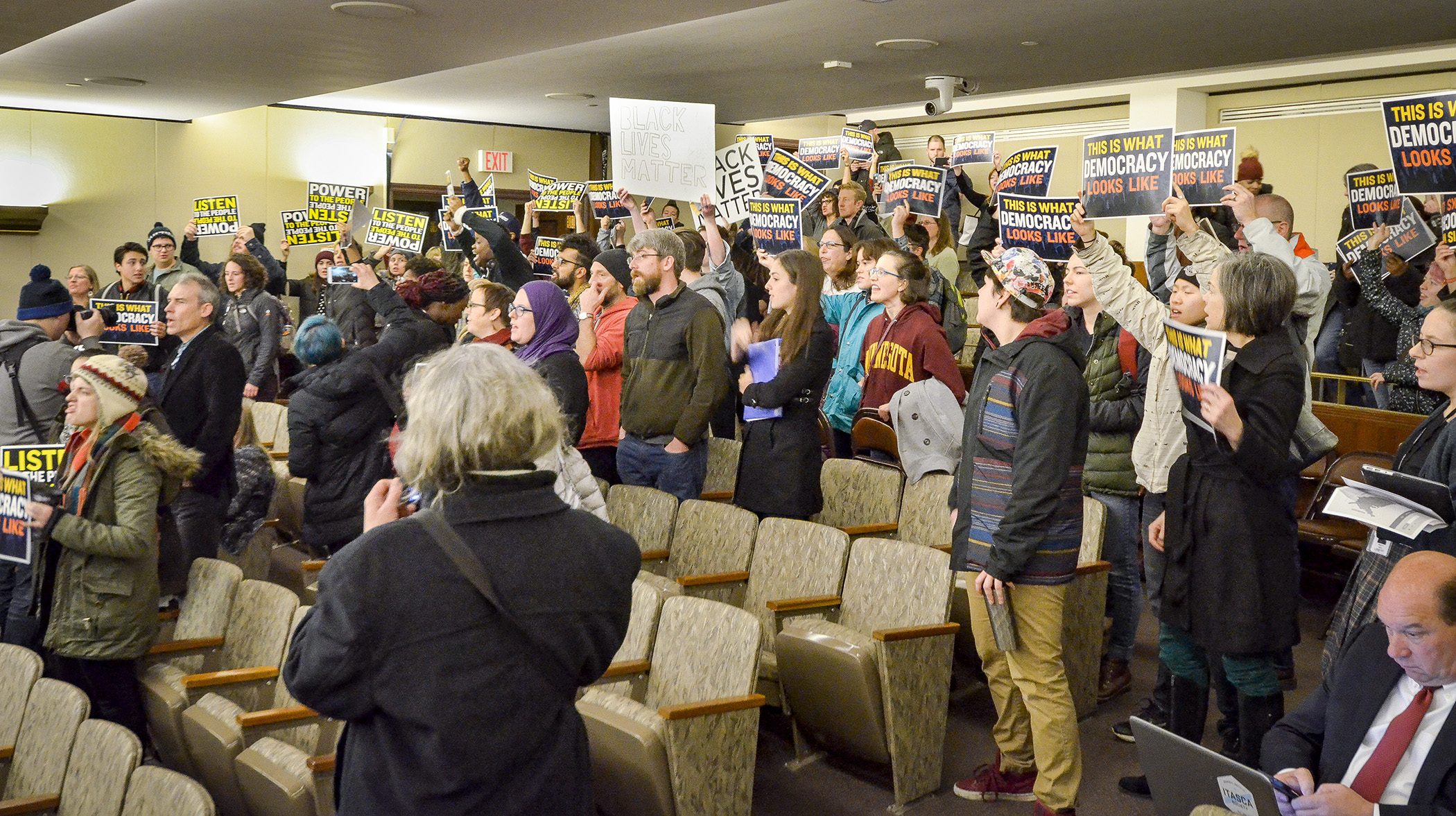 Audience members at the House Civil Law and Data Practices Policy Committee erupt in protest Jan. 24 after lawmakers approved a bill that would allow governmental units to sue to recover costs related to unlawful assemblies and public nuisances.  Photo by Andrew VonBank